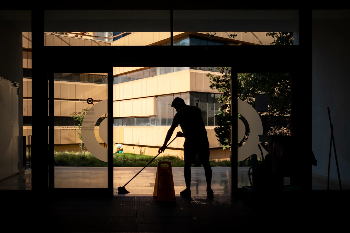 Commercial cleaner mopping the floor of a modern office entrance